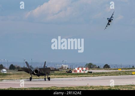 A ÉTATS-UNIS Force aérienne F-35 Lightning II, affecté au 134th Escadron de chasseurs, Vermont la Garde nationale aérienne atterrit à la base aérienne de Buckley, Colorado, tandis qu'un F-16D Fighting Flacon, affecté au 21st Escadron de chasseurs, Arizona Air National vole pour le 100th anniversaire de l'ANG du Colorado, 8 mai 2023. Le « REDEYES » a effectué un vol de formation de trois navires avec un P-51 Mustang, un F-35 Lightning II, un F-16C Faucon Fighting et un F-16D Faucon Fighting pour commémorer la célébration du centenaire de la FS 120th. (É.-U. Photo de la Force aérienne par le sergent d'état-major Devin M. Rumbaugh) Banque D'Images