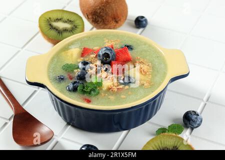 Saladier à la smoothie avec garniture aux myrtilles, ananas, céréales et myrtilles. Fruits d'été frais concept jus sain bols fruités Banque D'Images