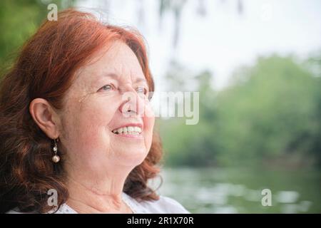 Portrait d'une femme latine senior souriant naturellement. Composition lumineuse avec espace de copie. Concept: Tranquillité et bonheur en profitant de temps de loisirs dans la durée Banque D'Images