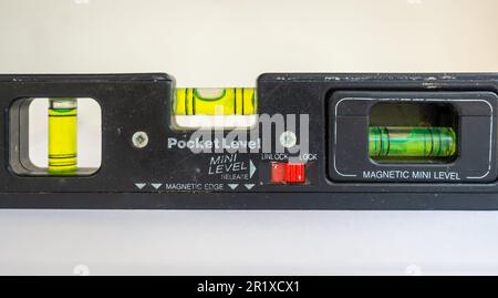 Outil de construction à niveau à bulle en plastique noir. Isolé sur fond blanc. Utilisé dans les travaux de construction. Banque D'Images