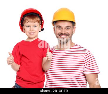 Un père et un fils heureux en casque de sécurité montrant les pouces sur fond blanc. Travaux de réparation Banque D'Images