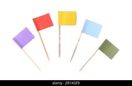 Ensemble de cure-dents avec petits drapeaux en papier colorés sur fond blanc, vue du dessus Banque D'Images