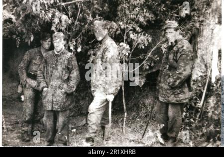 Photo B&W de la Seconde Guerre mondiale les soldats allemands à Camo Smocks reposent sous les arbres derrière la Front Line Normandy 1944 . Les hommes sont de la SS Panzergrenadier Division Gotz von Berlichingen 17th Banque D'Images