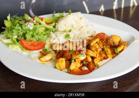 Poulet braisé avec légumes et un peu de riz et de salade. Banque D'Images