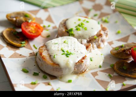 Filet de porc cuit avec une sauce au fromage. Banque D'Images