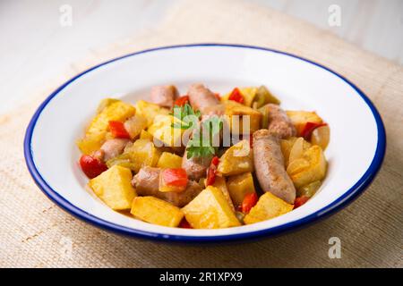 Saucisses de porc braisées avec sauce tomate et autres légumes. Banque D'Images