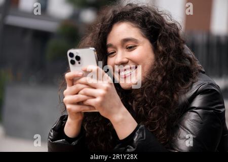 Une jeune femme souriante, influenceur de blogueur, utilise son smartphone Banque D'Images
