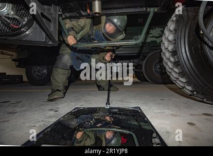 NANNING, CHINE - le 16 MAI 2023 - un agent d'élimination des explosifs inspecte le dessous d'une voiture avec un miroir d'inspection inférieur pendant un explosif Banque D'Images