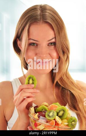 Young woman eating fruit salad Banque D'Images