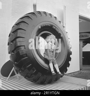 Dans le 1950s. Un petit garçon est assis sur un pneu géant exposé sur l'exposition Sankt Eriks-mässan à Stockholm en 1950. Une exposition présentant les derniers 1950s produits pour le public. Suède 1950. Conard réf. 1453 Banque D'Images