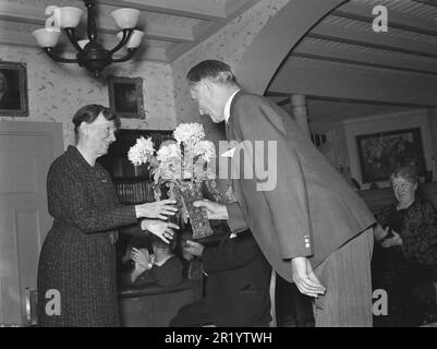 Anniversaire en 1930s. Une dame âgée reçoit une fleur dans un vase avec des fleurs de pivoines par un homme tout aussi vieux, se fauve poliment en les remettant. Les gens dans la pièce derrière eux applaudissent. Ils sont résidents de la maison de retraite Höstsol où les acteurs plus âgés vivent dans leurs jours d'or. Novembre 1939. Kristoffersson réf. 40-4 Banque D'Images