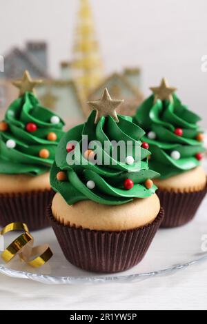 Petits gâteaux en forme d'arbre de Noël sur table blanche Banque D'Images