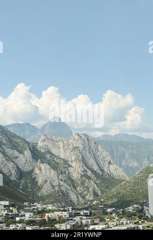 Ville près des montagnes sous ciel bleu avec nuages Banque D'Images