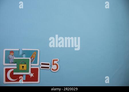 Opération mathématique avec des puzzles éducatifs placés sur le bord de l'arrière-plan bleu. collection, cinq Banque D'Images