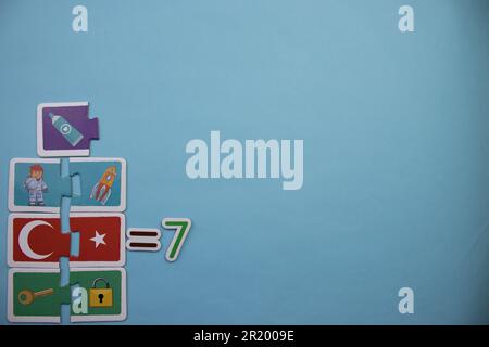 Opération mathématique avec des puzzles éducatifs placés sur un fond bleu. collection, 7 Banque D'Images