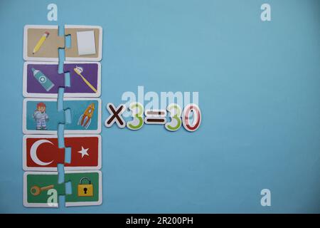 Opération mathématique avec des puzzles éducatifs placés sur un fond bleu. Multiplication, trois Banque D'Images