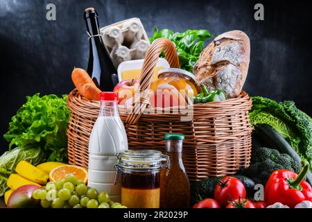Panier en osier avec assortiment de produits d'épicerie, y compris des légumes frais et fruits Banque D'Images