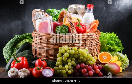 Panier en osier avec assortiment de produits d'épicerie, y compris des légumes frais et fruits Banque D'Images