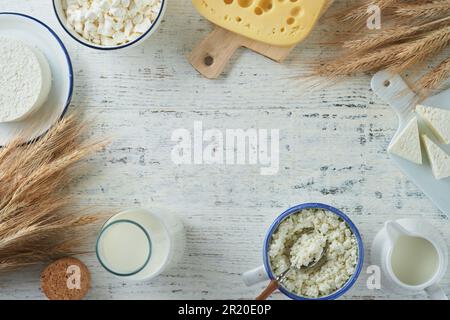 Fête juive de Shavuot. Kasher produits laitiers frais lait et fromage, blé mûr, crème sur fond de bois blanc. Les produits laitiers sur le whi Banque D'Images