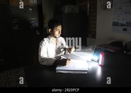 Délestage 16 may2023, paltan dhaka bangladeshA homme travaille avec le témoin du chargeur allumé en raison de l'délestage.photo a été prise paltan Dhaka Banclaies Banque D'Images