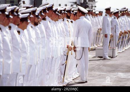 Le commandant de bord inspecte des divisions de marins en uniforme sur le HMS Invincible, 1984 Banque D'Images