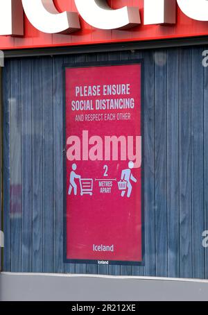 Photographie d'un panneau à l'extérieur du supermarché Islande demandant aux clients de respecter les mesures de distanciation sociale mises en place pendant la pandémie COVID-19. Banque D'Images