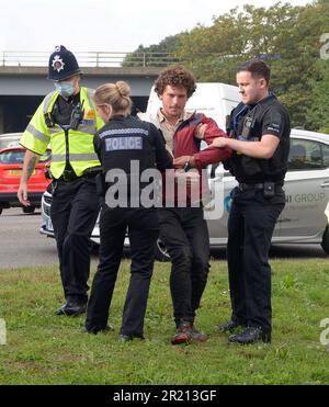 La police arrête les manifestants pour le changement climatique qui ont tenté de bloquer le M25 à la jonction 28 près de Brentwood, dans l'Essex, car ils exigent une action gouvernementale sur l'isolation de leur domicile. Plus de 100 personnes ont été arrêtées en trois jours de manifestations. Le groupe de protestation Isolate Britain a déclaré que l'action se poursuit jusqu'à ce qu'un « engagement de comportement » soit pris. Septembre 2021. Banque D'Images