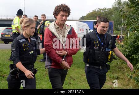 La police arrête les manifestants pour le changement climatique qui ont tenté de bloquer le M25 à la jonction 28 près de Brentwood, dans l'Essex, car ils exigent une action gouvernementale sur l'isolation de leur domicile. Plus de 100 personnes ont été arrêtées en trois jours de manifestations. Le groupe de protestation Isolate Britain a déclaré que l'action se poursuit jusqu'à ce qu'un « engagement de comportement » soit pris. Septembre 2021. Banque D'Images