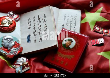 Pendant la Révolution culturelle, le culte de la personnalité de Mao s'est manifesté dans le port omniprésent de badges représentant le président Mao, et de personnes portant un petit livre rouge avec les écrits de Mao, qui seraient étudiés et cités à chaque occasion. Banque D'Images