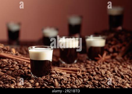 Cocktail russe blanc. Vodka, liqueur de café et crème. Les grains de café, la cannelle et l'anis sont éparpillés sur la table. Banque D'Images