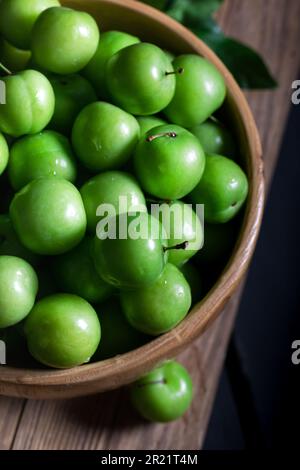 Prunes vertes fraîches dans un bol. Gros plan de prunes vertes fraîches. Banque D'Images