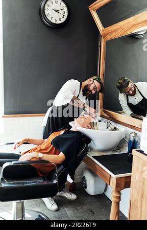 Un bon lavage peut faire des merveilles pour vos cheveux. une jeune femme attirante se laver les cheveux et stylisée par un coiffeur à l'intérieur d'un salon de coiffure. Banque D'Images