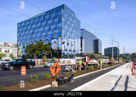 BELLEVUE, WA, États-Unis – 3 MAI 2023 : Spring District, nouvelle construction de bâtiments de bureaux en verre avec des équipes de route travaillant sur la rue et la médiane Banque D'Images