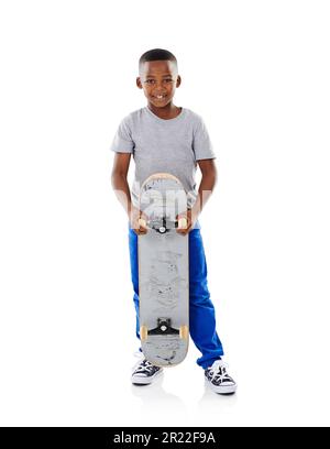 Allons faire du patinage. Photo en studio d'un petit garçon mignon posant avec son skateboard sur un fond blanc. Banque D'Images