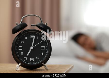 Femme dormant dans la chambre, se concentrer sur le réveil. Espace pour le texte Banque D'Images