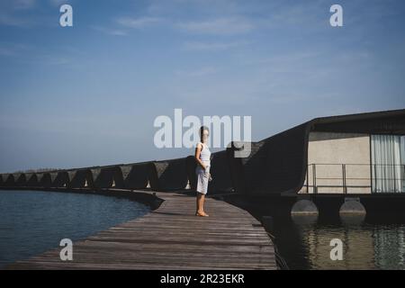 Sérénité au milieu du luxe une femme se tenant sur le plancher en bois d'un complexe. Banque D'Images