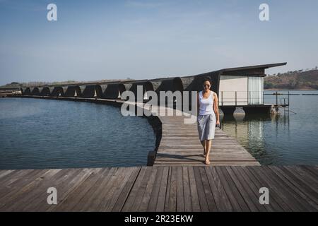 Sérénité au milieu du luxe une femme marchant sur le parquet d'un complexe. Banque D'Images