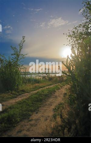 Photo prise en Ukraine. La photo est une route rurale vers le lac pendant le coucher du soleil. Banque D'Images