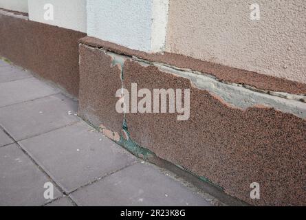 Plâtre endommagé de la plinthe et de la fondation de la maison. Le plâtre décoratif protège la maison de l'humidité, de l'humidité et des murs de la destruction Banque D'Images