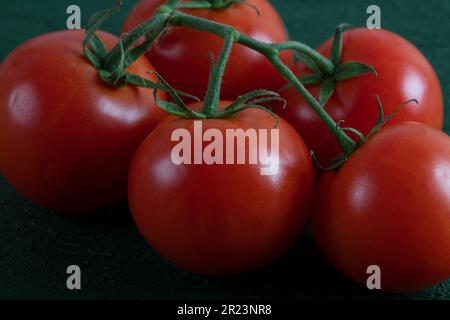 Un groupe de tomates de raisin sur fond vert, gros plan Banque D'Images
