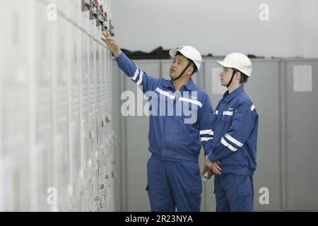 (230517) -- ZHANATAS, 17 mai 2023 (Xinhua) -- Maksat Abilgaziev (L) et son collègue vérifient le matériel de distribution électrique du parc éolien de Zhanatas à Zhanatas, au Kazakhstan, sur 3 avril 2023. La Chine et le Kazakhstan sont des pionniers en matière de capacité de production et de coopération en matière d'investissement, dans le cadre de la synergie entre l'Initiative ceinture et route et la nouvelle politique économique du Kazakhstan sur la « route de la soie ». La liste de coopération comprend 52 projets d'une valeur totale de plus de 21,2 milliards de dollars américains. Le parc éolien Zhanatas de 100 MW est l'un des premiers projets énergétiques clés du Kazakhstan-Chine Banque D'Images