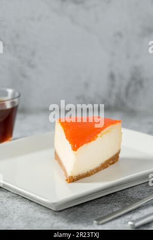 Cheesecake à la citrouille sur une assiette en porcelaine avec thé sur une table en pierre Banque D'Images