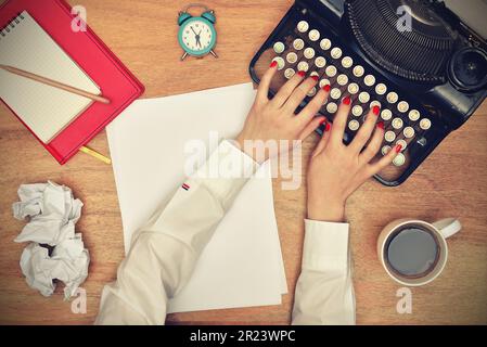 Dactylographier les mains sur une machine à écrire Vintage. Vue de dessus Banque D'Images