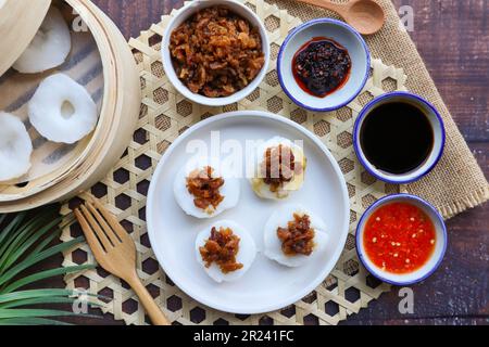 Gâteau au riz cuit à la vapeur avec navet conservé servi avec une sauce au soja et à la sauce Chili - dans la cuisine chinoise appelée Chwee Kueh sur une table en bois Banque D'Images