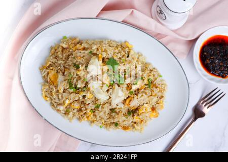 Crabe Fried Rice - cuisine asiatique servie dans un endroit blanc de table en marbre avec vue sur le dessus Banque D'Images