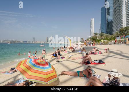 Bains de soleil et gratte-ciel à Marina Beach, Dubaï, Émirats arabes Unis Banque D'Images