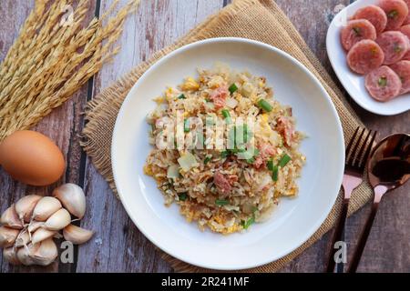 Riz frit avec du porc fermenté et des légumes - dans la cuisine thaïlandaise appelée Khao Pad Naem au sommet de la vue sur la table en bois Banque D'Images
