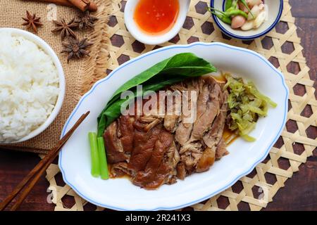 Cuisse de porc en compote avec légumes et riz en haut de la table en bois - (cuisine thaïlandaise - de style chinois) Banque D'Images