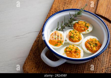 Œufs farcis à la crème de thon et de tomate. Recette traditionnelle de tapa espagnole. Banque D'Images