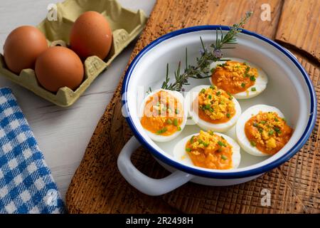 Œufs farcis à la crème de thon et de tomate. Recette traditionnelle de tapa espagnole. Banque D'Images